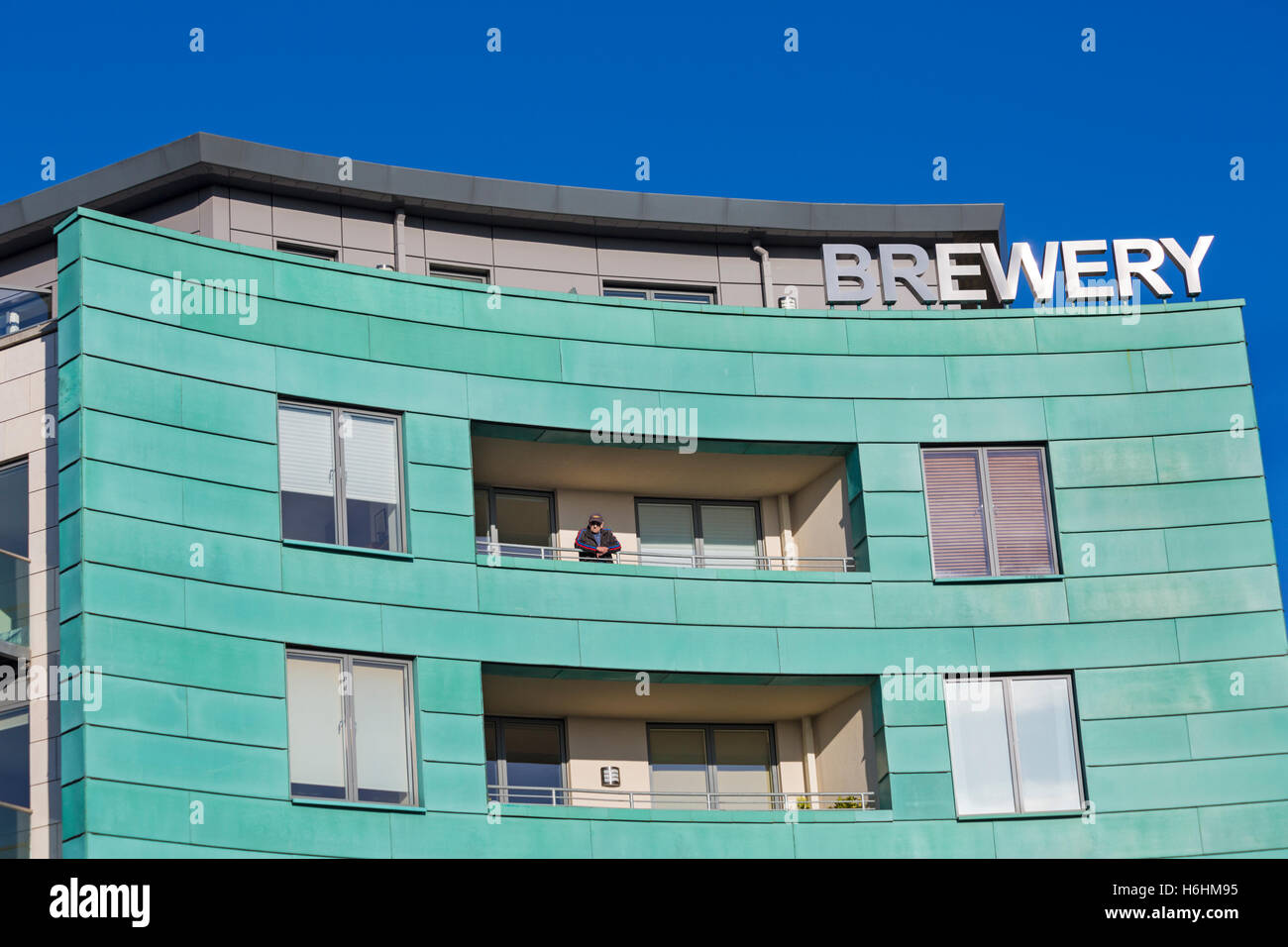Man on balcony of apartments at Brewery Square, Dorchester in October Stock Photo