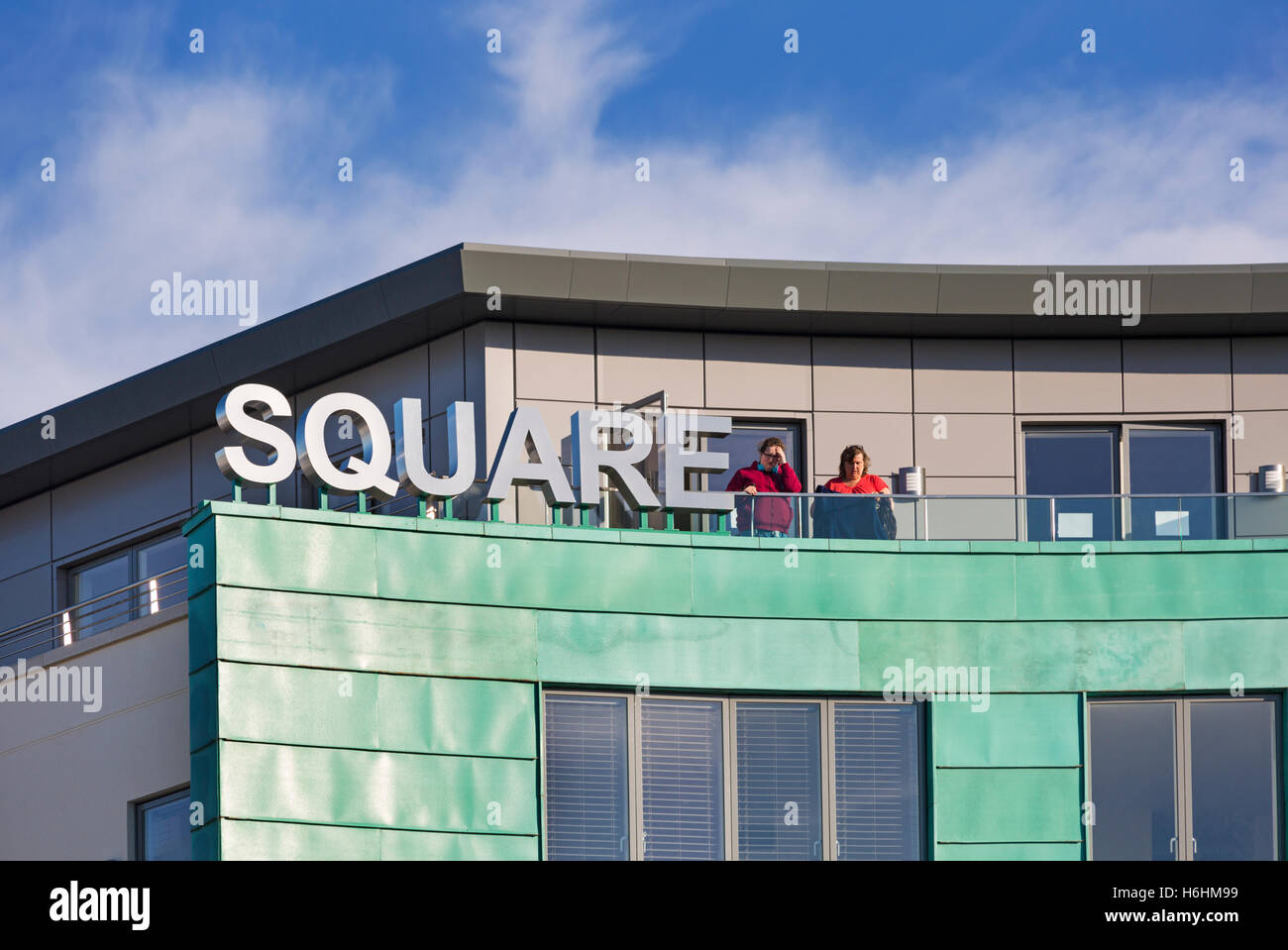 Women on top floor balcony of apartments at Brewery Square, Dorchester in October Stock Photo