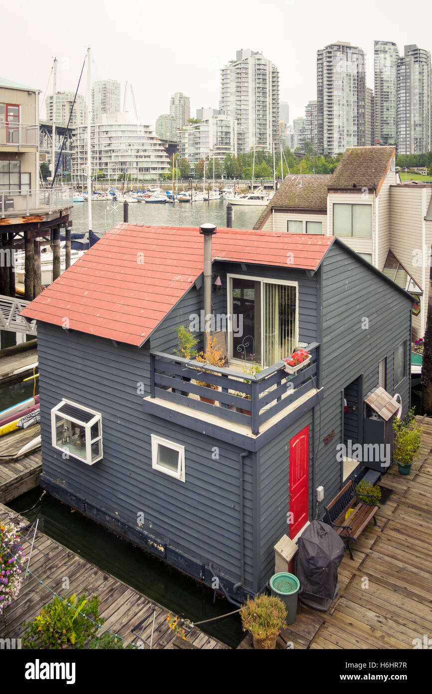 The Sea Village houseboats on Granville Island in Vancouver, Canada. The glass towers of