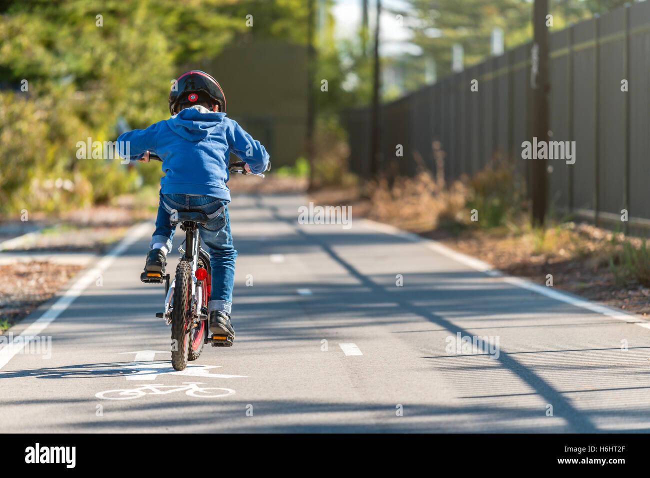 Australian boy riding his bicycle on bike lane on a day, South