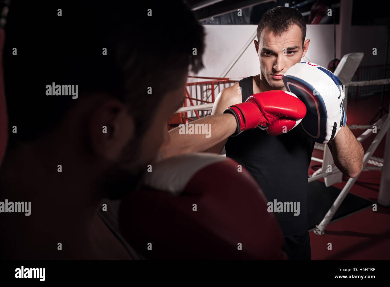 Young trainer holding boxing pad Stock Photo Alamy