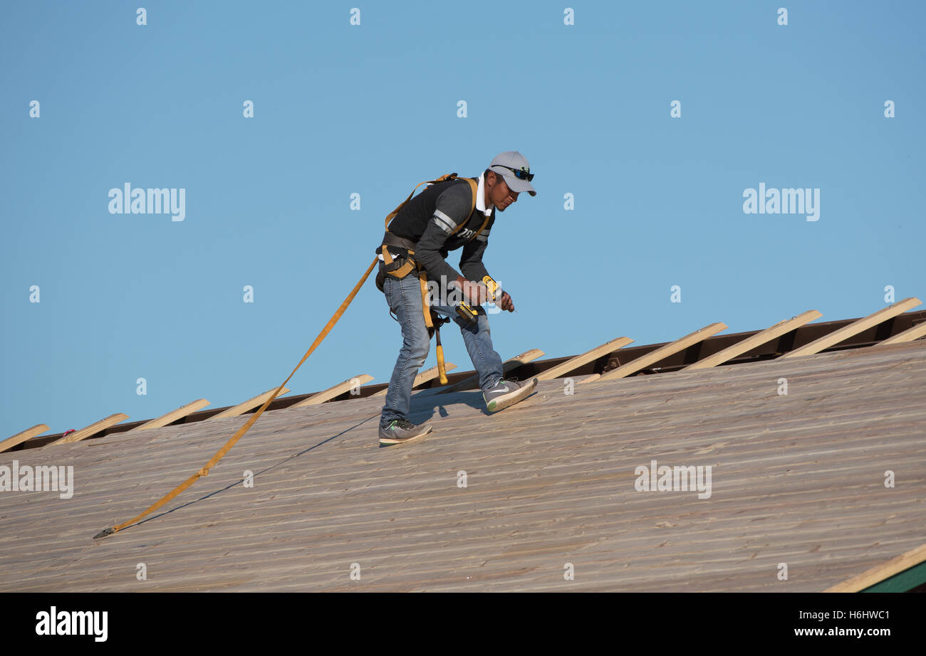 https://c8.alamy.com/comp/H6HWC1/florida-usa-roofer-wearing-a-safety-harness-and-holding-a-drill-to-H6HWC1.jpg