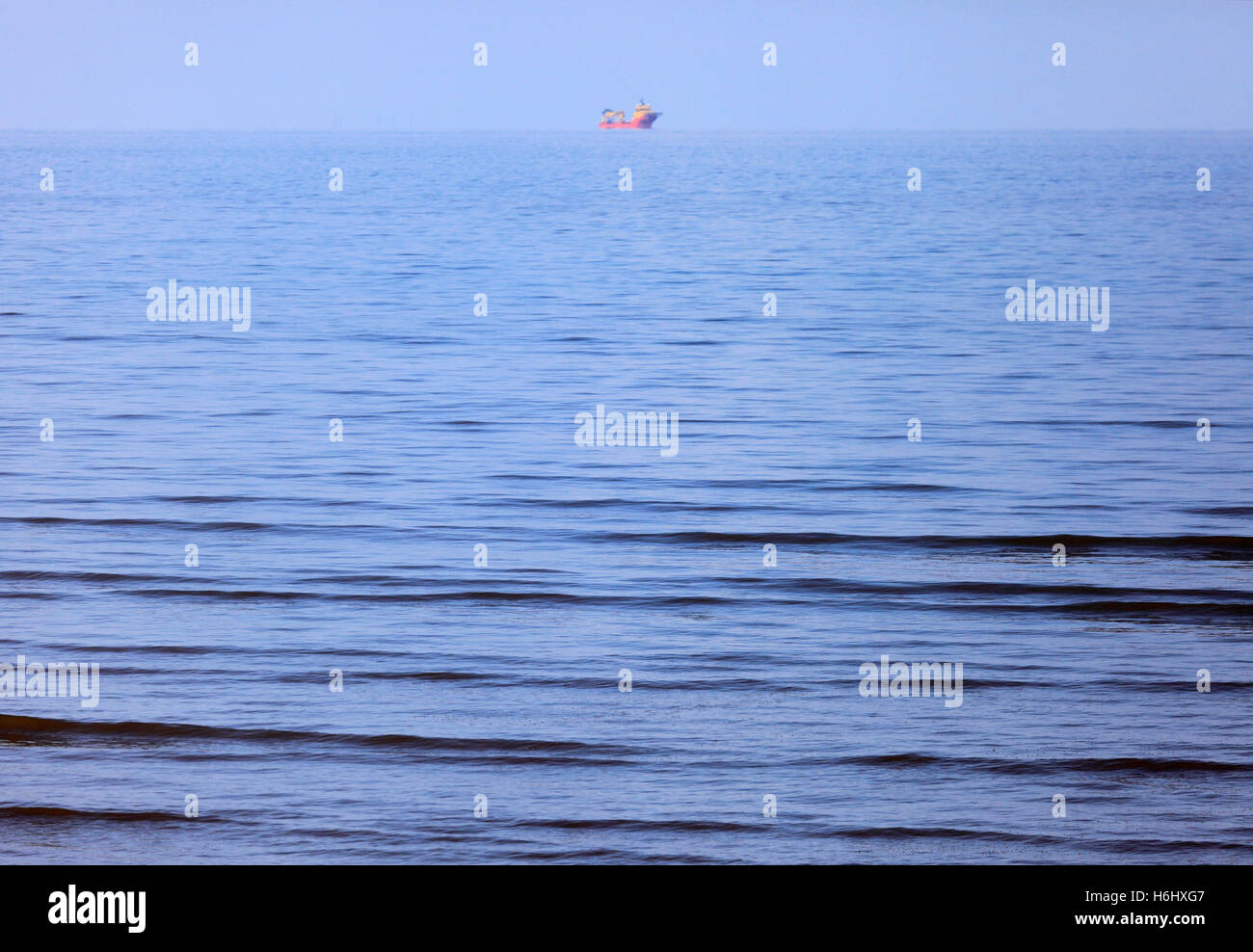 A solitary red boat on the blue sea. Stock Photo