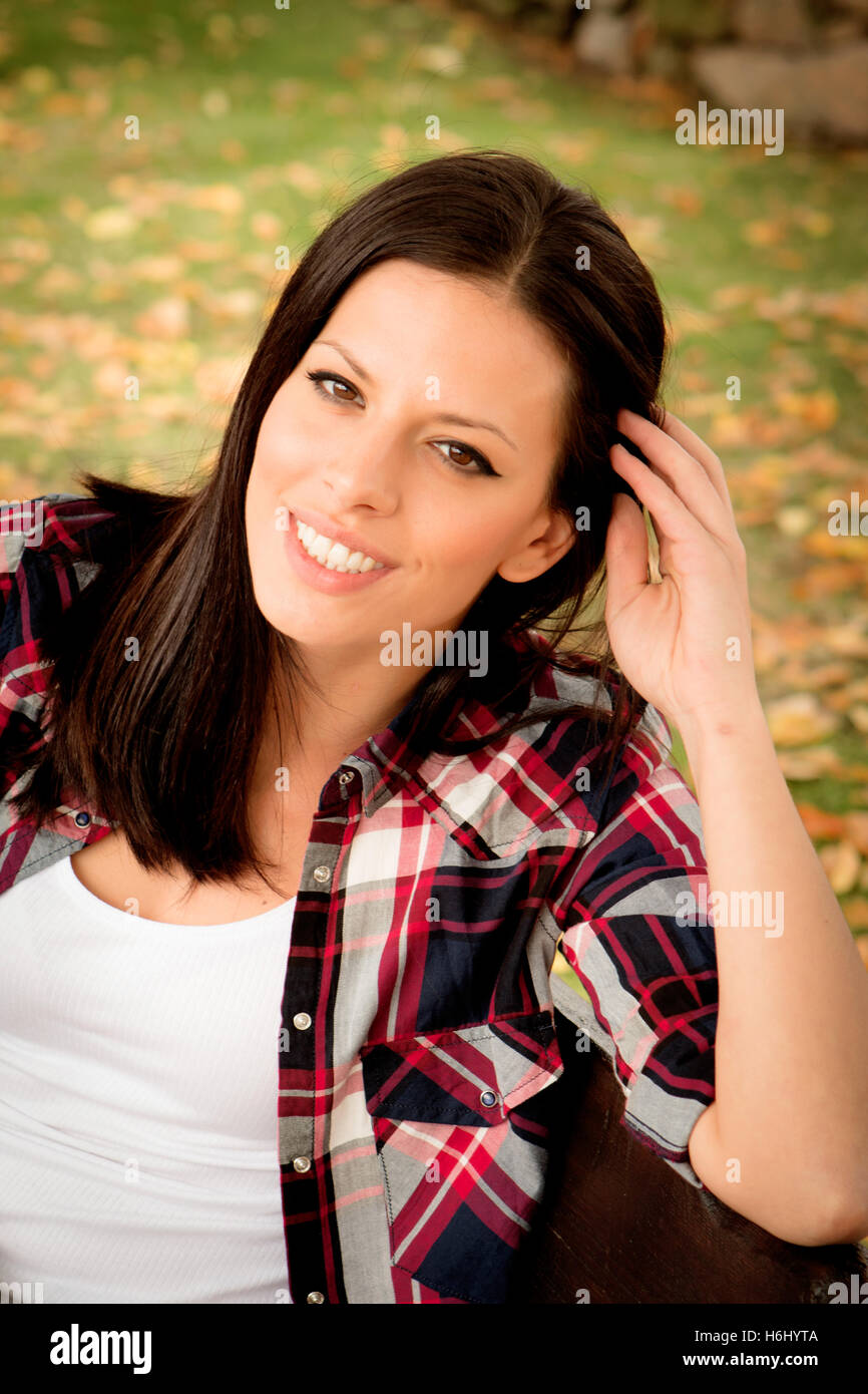 Beautiful young woman sitting on a bench in park at fall Stock Photo ...