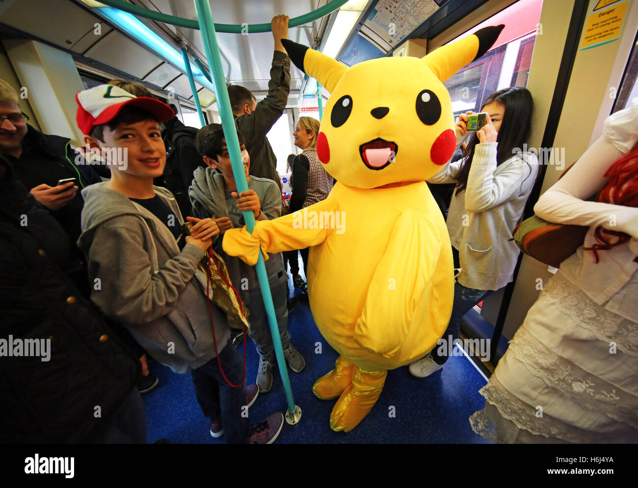 London, UK. 29th October 2016. Pikachu from Pokemon, aka 12 year old John from London, rides the DLR, Dockland Light Railway, to day two of MCM London Comic Con, one of the largest pop culture events in the UK taking place at Excel London. Credit:  Paul Brown/Alamy Live News Stock Photo