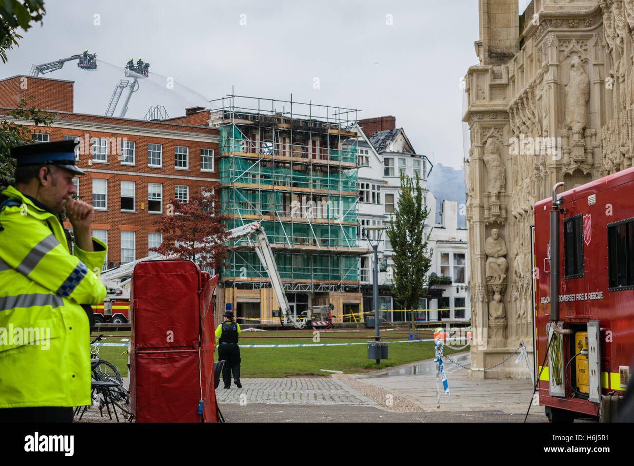 Exeter, Devon, England, UK - 29 October 2016: Concerned policeman at the Cathedral green look at what is left of the oldest hotel in England, Royal Clarence Hotel. Credit: Cristina Neacsu/Alamy Live News Stock Photo