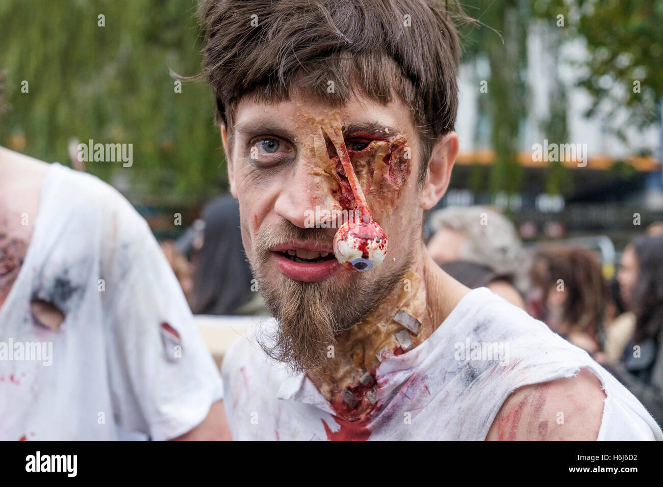 Bristol, UK. 29th Oct, 2016. A man with a painted face,make up and dressed as a zombie is pictured as she participates in a Zombie Walk In Bristol. Credit:  lynchpics/Alamy Live News Stock Photo