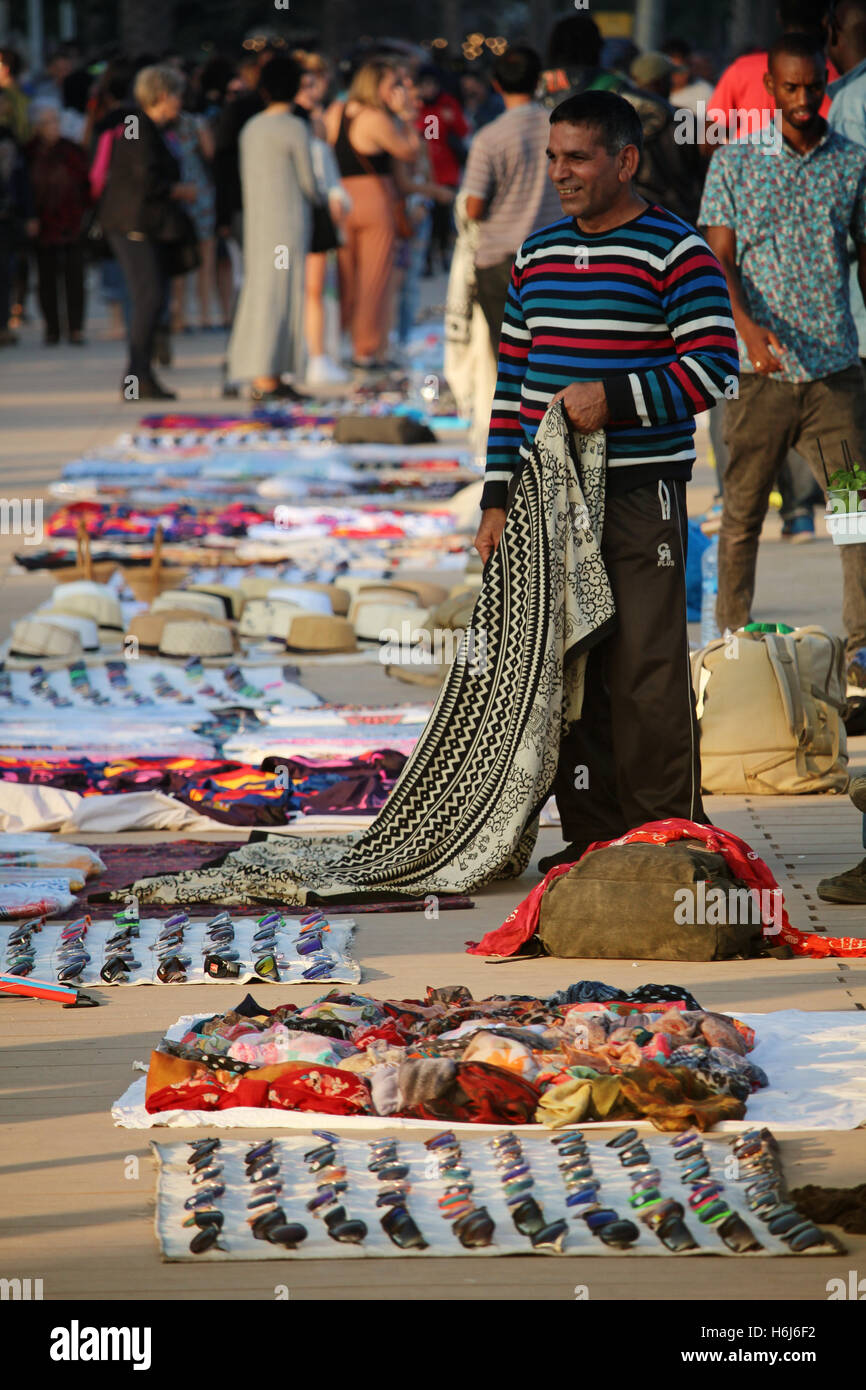 Barcelona, Spain - October 29, 2016: Illegal sellers of fake branded clothes on the Barceloneta beach. Although it is illegal, the phenomenon called 'top manta' is extended in central Barcelona, with hundreds of street sellers in the most popular tourist locations of the city Credit:  Dino Geromella/Alamy Live News Stock Photo