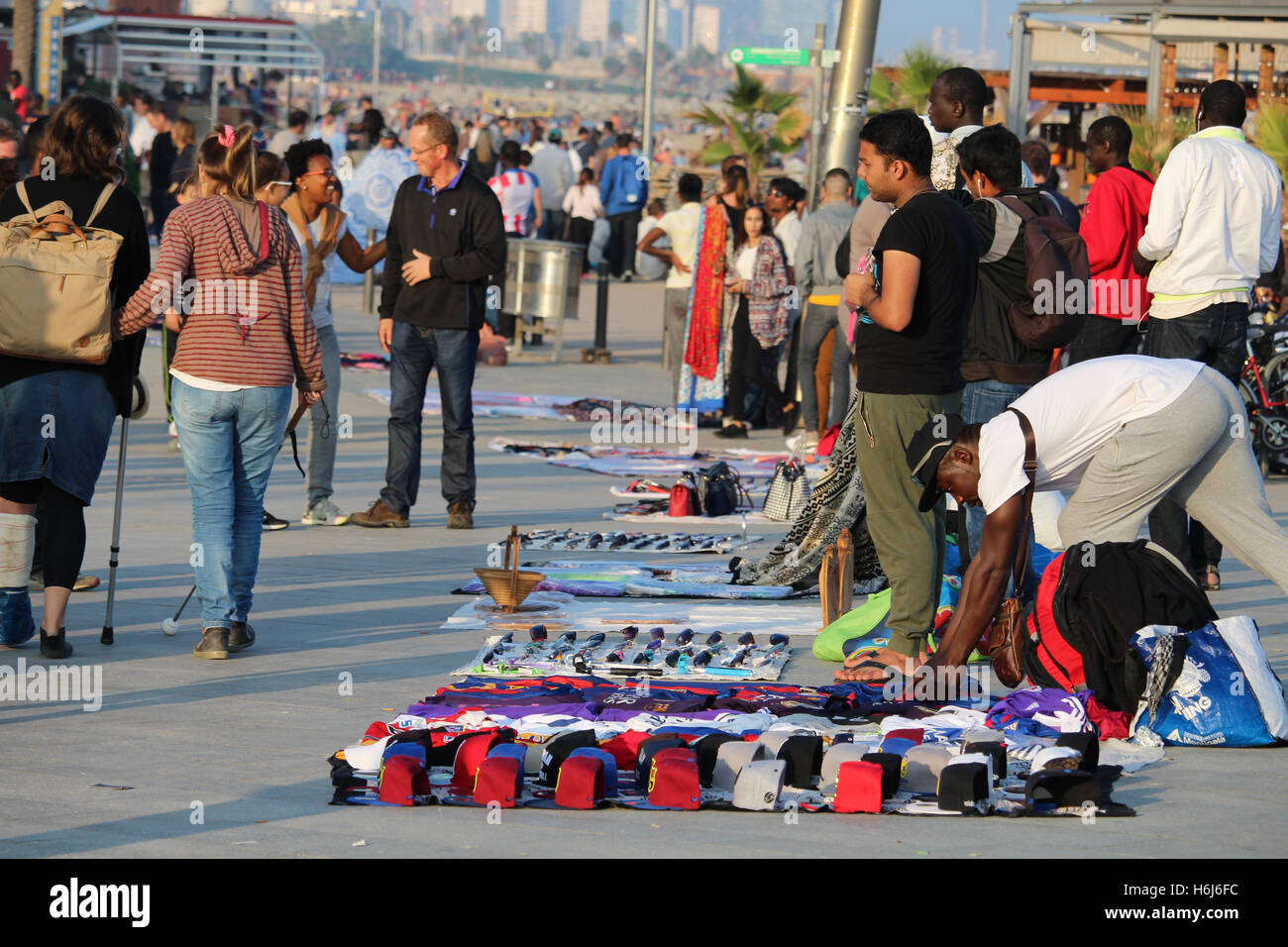 Barcelona, Spain - October 29, 2016: Illegal sellers of fake branded clothes on the Barceloneta beach. Although it is illegal, the phenomenon called 'top manta' is extended in central Barcelona, with hundreds of street sellers in the most popular tourist locations of the city Credit:  Dino Geromella/Alamy Live News Stock Photo