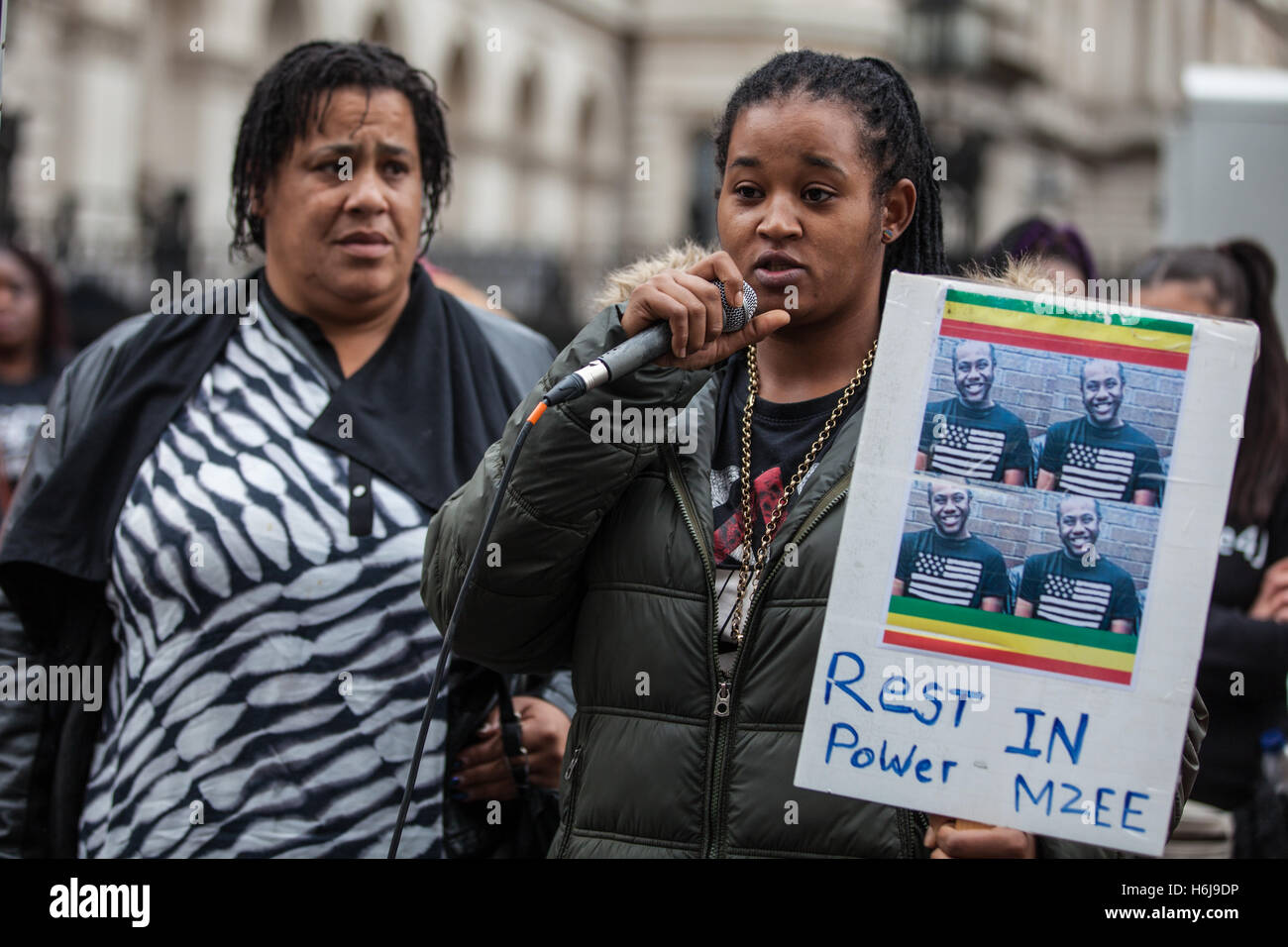 London, UK. 29th October, 2016. The cousin of Mzee Mohammed stands with his mother as she addresses campaigners from the United Families and Friends Campaign (UFFC) outside Downing Street following their annual procession. Mzee Mohammed, 18, died in July 2016 after being detained by Merseyside police at the Liverpool One shopping centre. Credit: Mark Kerrison/Alamy Live News Stock Photo