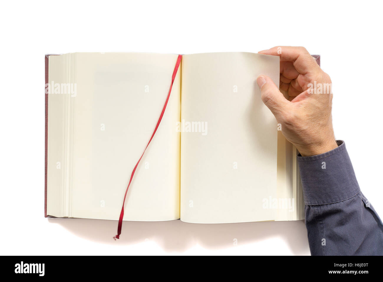 a man's hand turns the page of a blank book. Copy space. Isolated Stock Photo