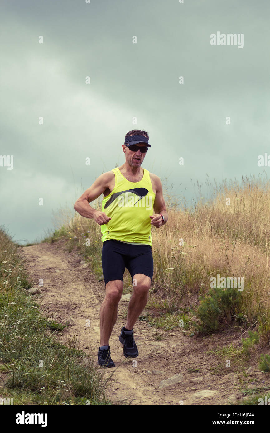 Athlete male runner running downhill on dirt road Stock Photo Alamy