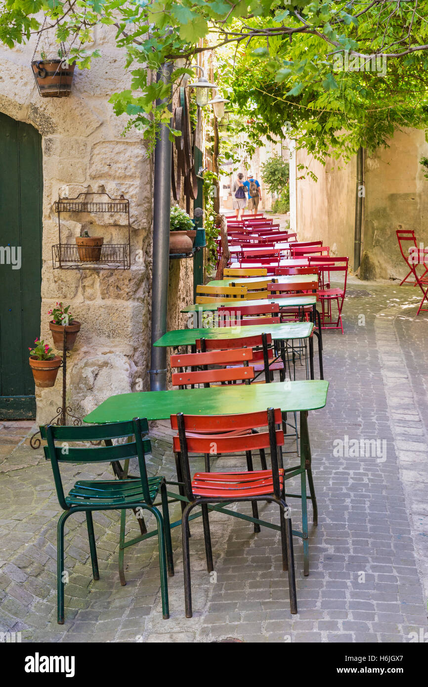 Narrow table and chair filled lane in the pretty medieval village of La Garde-Adhémar, Drôme, France Stock Photo