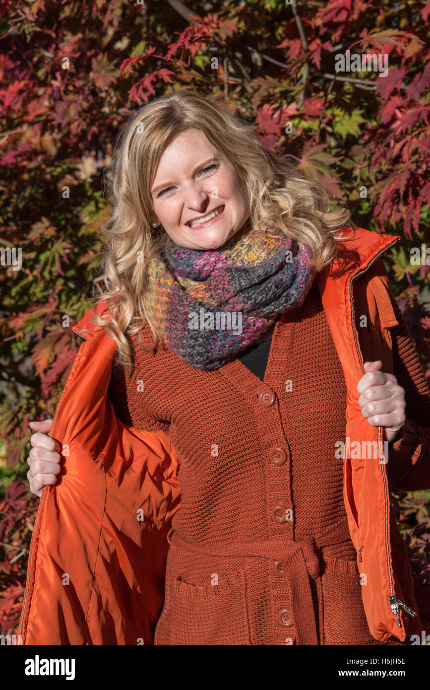 Attractive blond woman in the park is looking forward to the autumn Stock Photo
