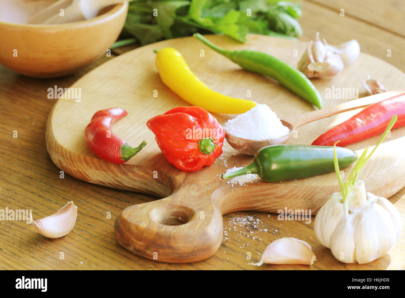 different variety of hot peppers and spices on cutting board Stock Photo