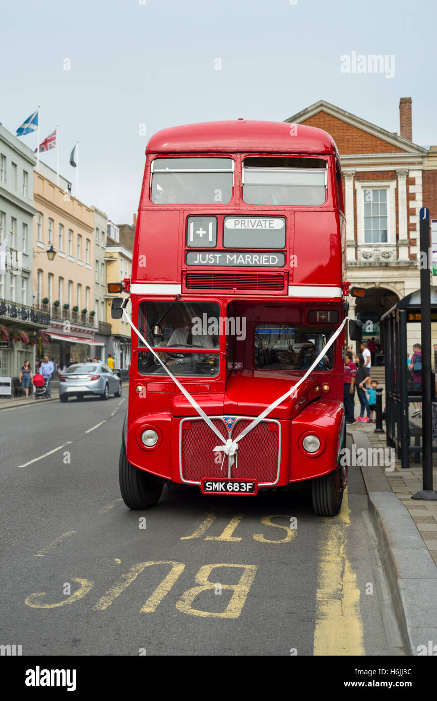 Traditional British red Routemaster double decker bus with marriage decoration for a wedding ceremony at a bust stop in a street in Windsor, UK Stock Photo