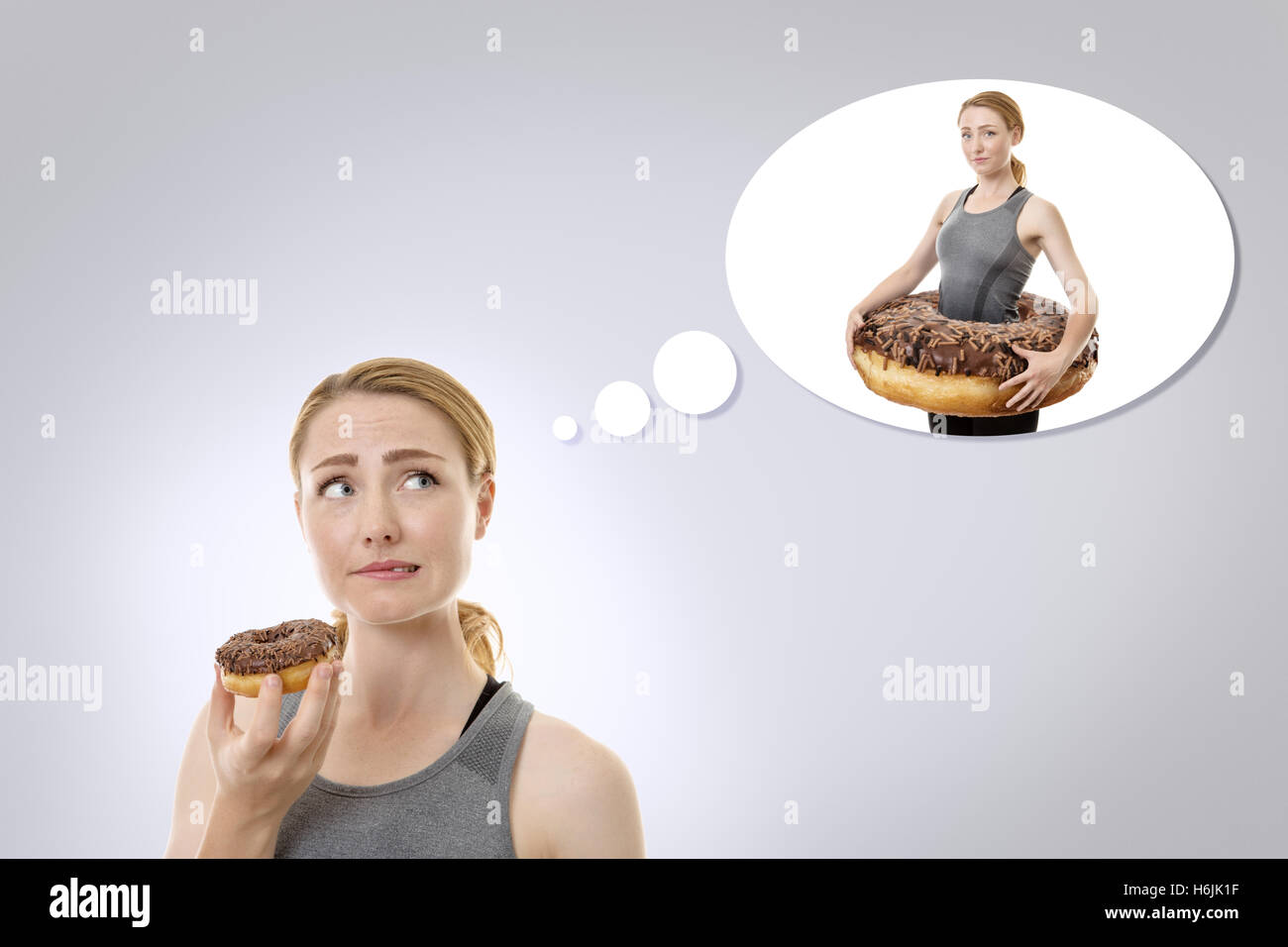 concept idea of a woman about to eat a donut but thinking she shouldn't