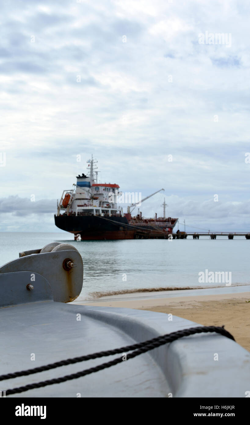 oil tanker vessel at dock with boat bow in foreground with anchor pulley Picnic Center Beach Big Corn Island Nicaragua Central A Stock Photo