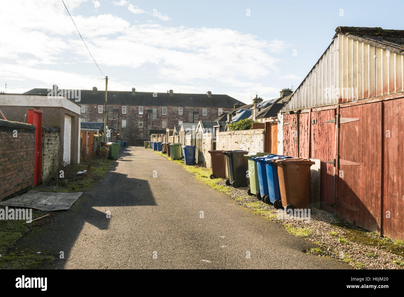 Alleyway with garages and dustbins in Dumbarton, Scotland, UK Stock Photo