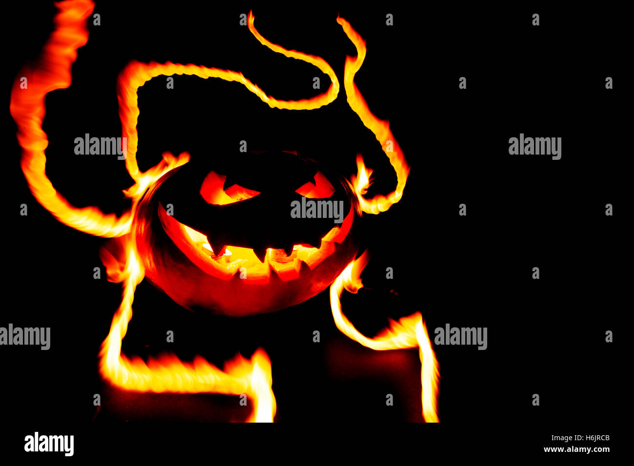 Scary smiling halloween pumpkin in flames on black background Stock ...