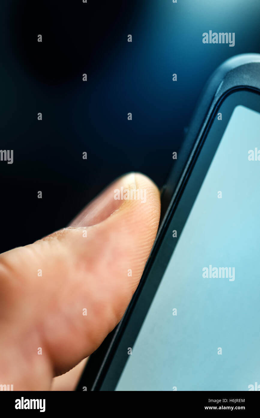 Unlocking smart phone with fingerprint sensor scan, close up with selective focus Stock Photo