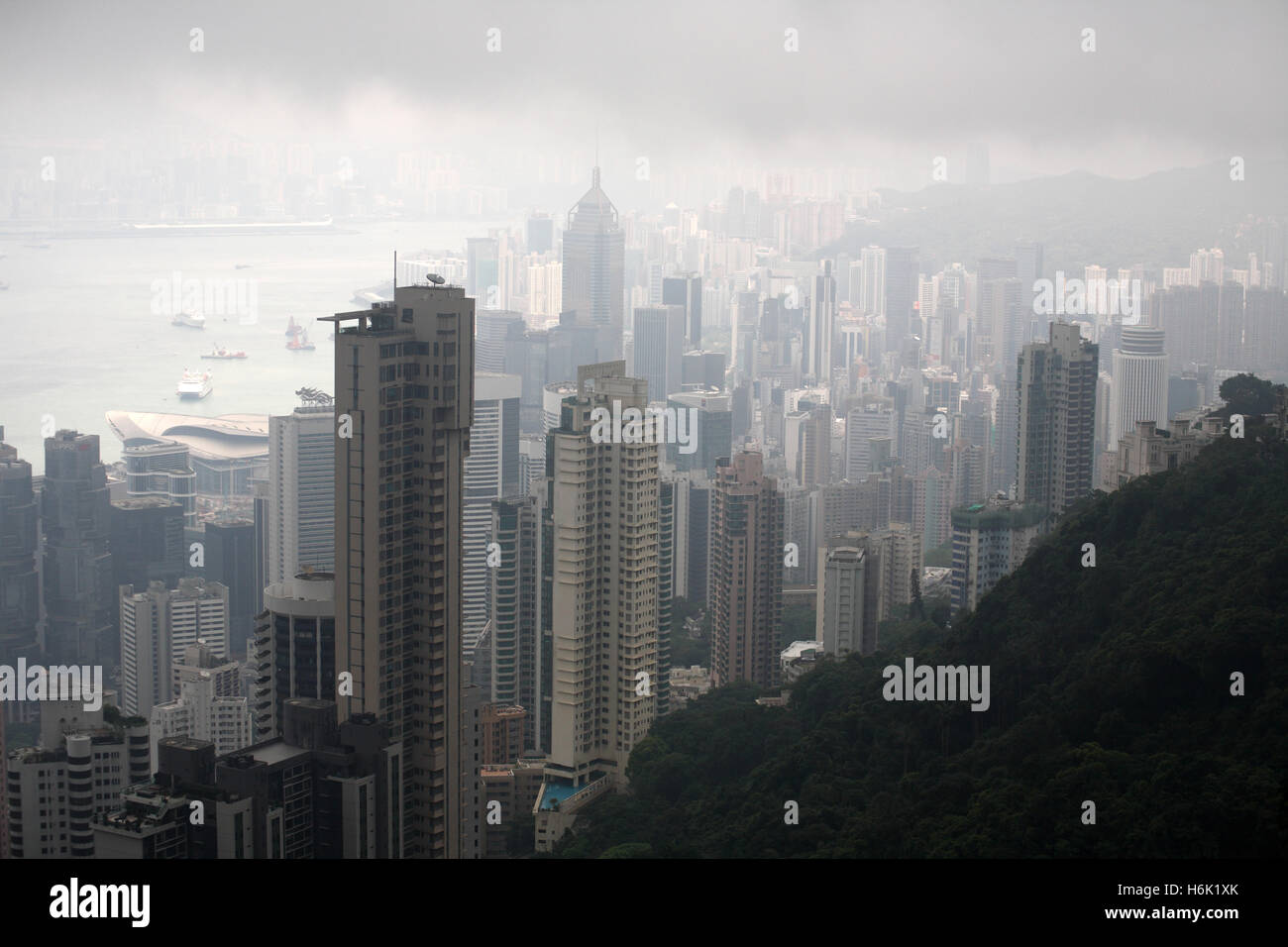 Skyline of Hong kong high rise residential and commercial buildings or towers and the Hong Kong Bay on a cloudy and foggy day. Stock Photo