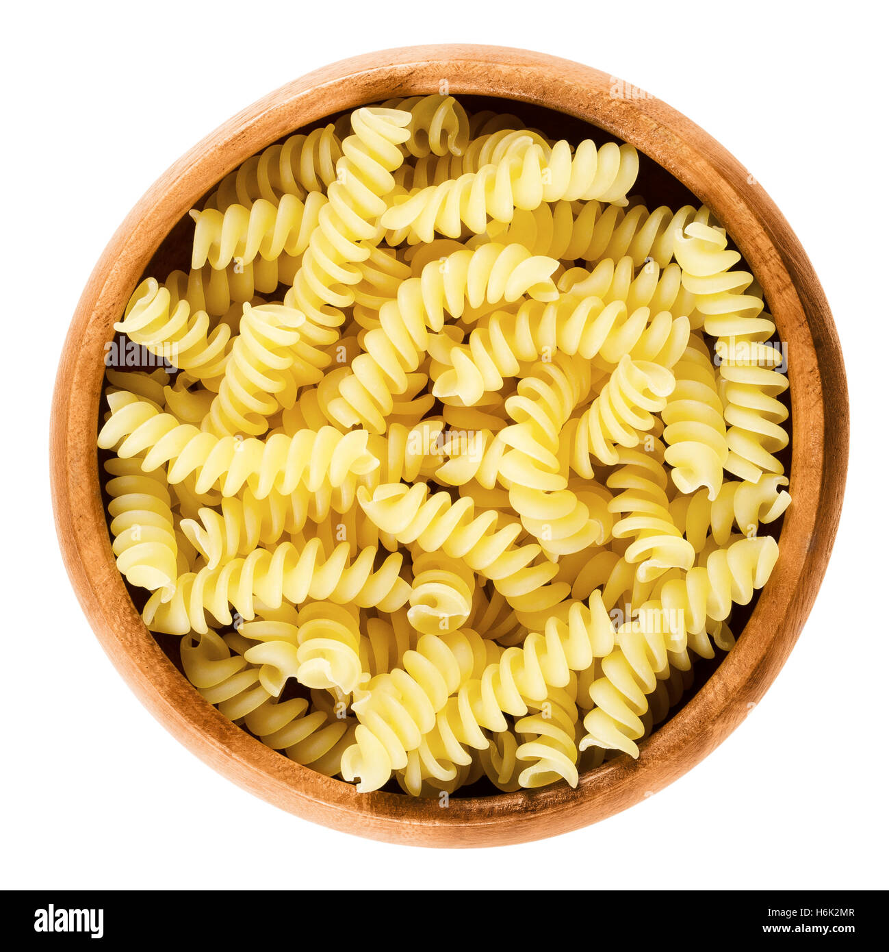 Girandole torsades pasta in wooden bowl. Uncooked dried durum wheat