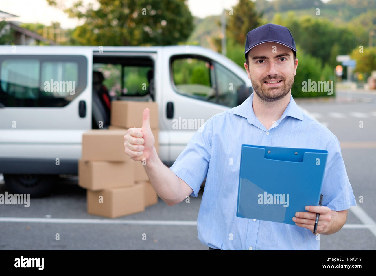 Portrait of confidence express courier next to his delivery van Stock Photo