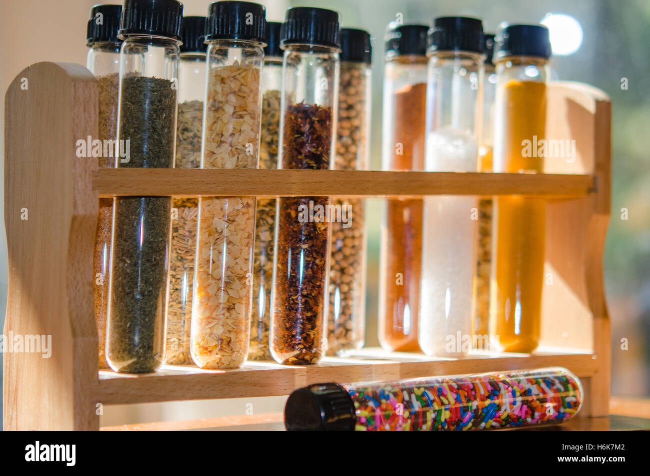 spices and sugar sprinkles in test tubes with lit background Stock