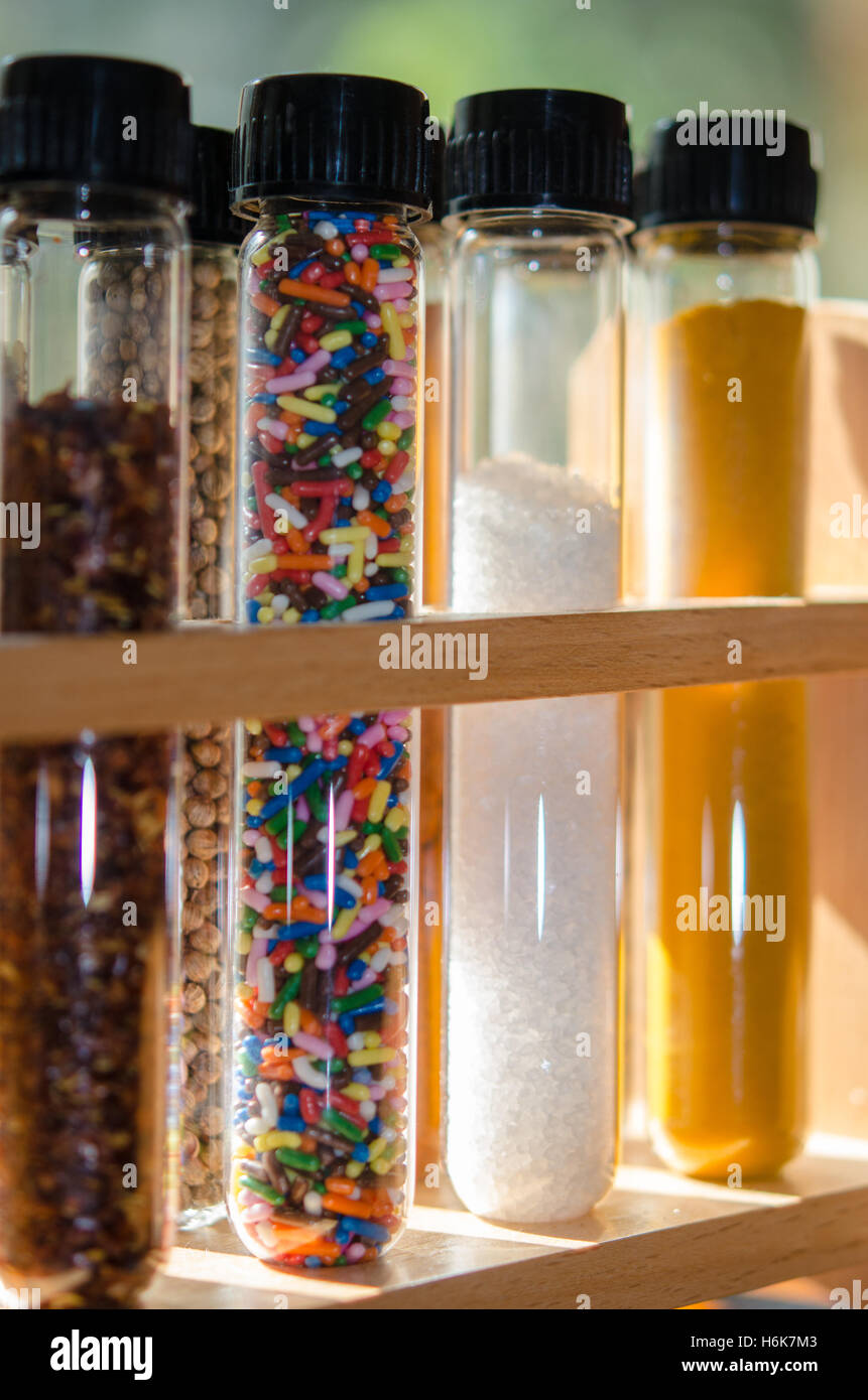 spices and sugar sprinkles in test tubes with lit background Stock