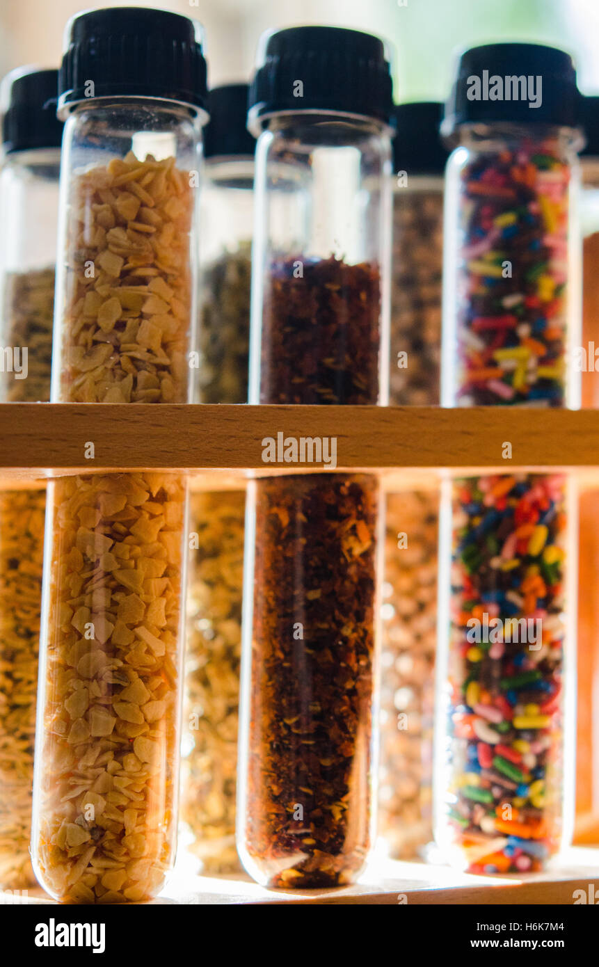 spices and sugar sprinkles in test tubes with lit background Stock
