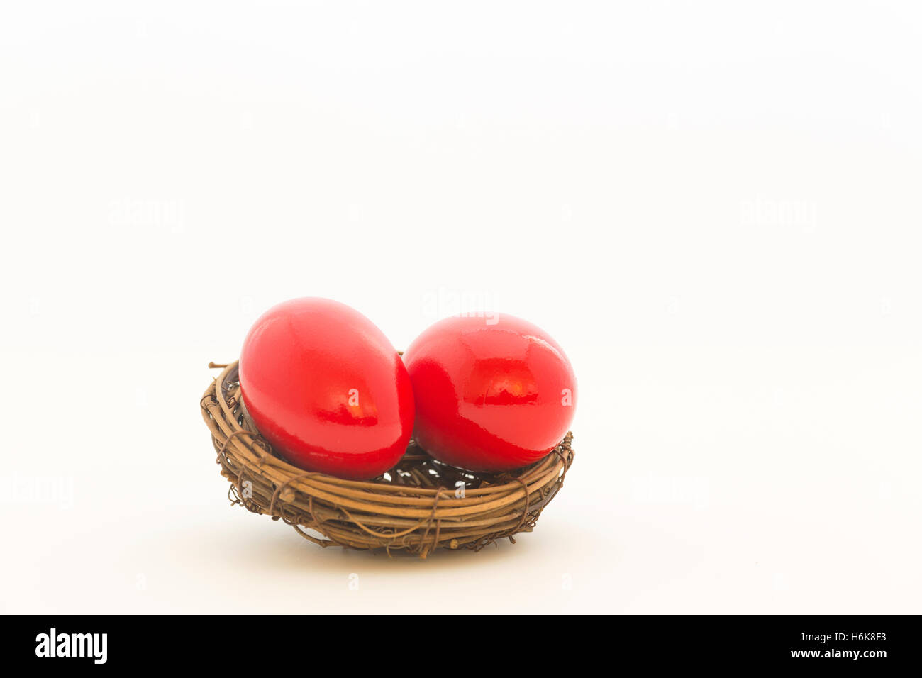 Two, crimson red nest eggs are symbols of endangered investments, pensions at risk, heavy debt, and repercussions. Stock Photo