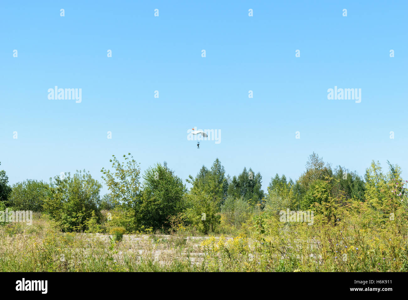 Paratroopers falling to earth on blue clear sky background Stock Photo