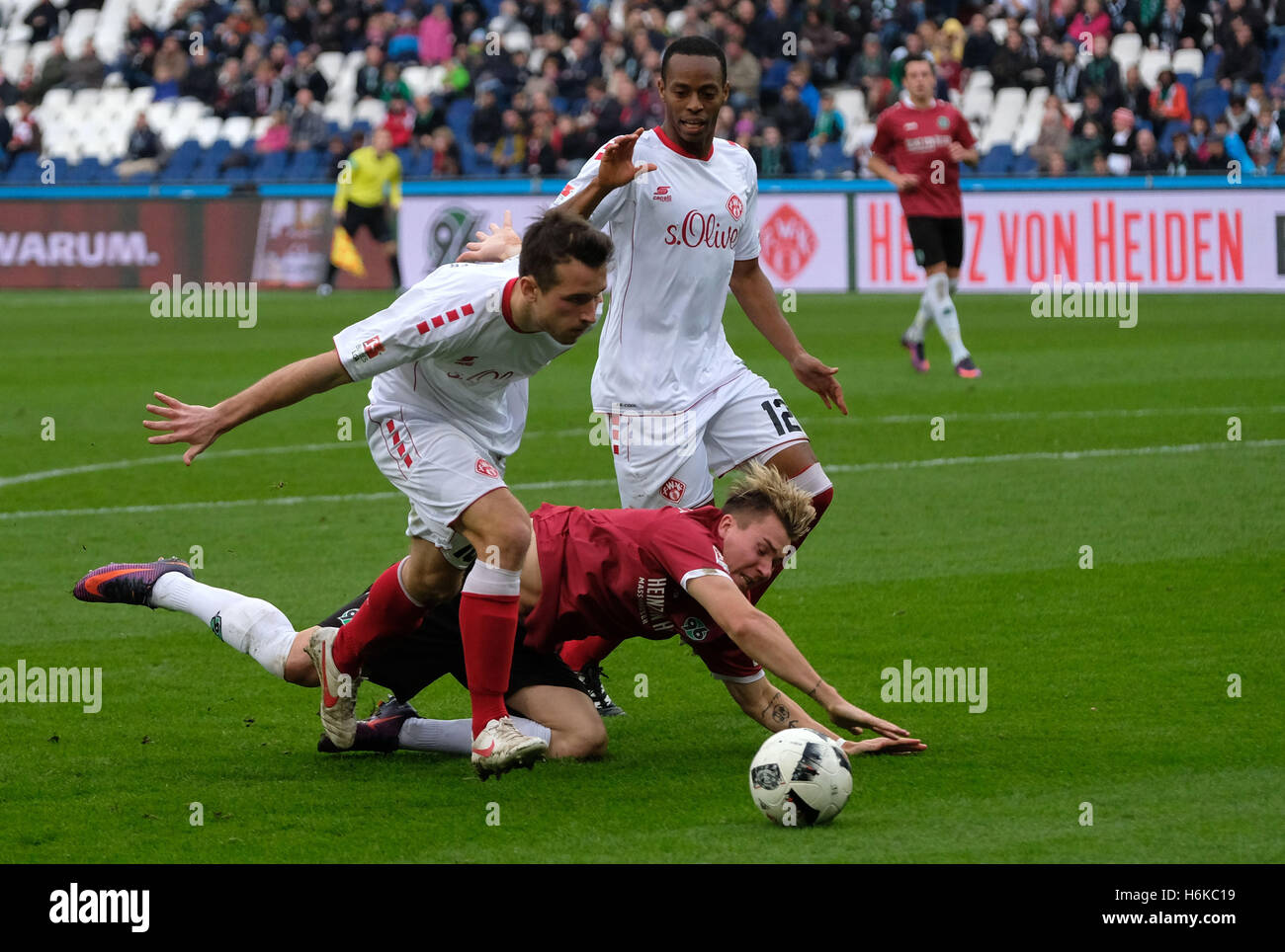 Hanover, Germany. 30th Oct, 2016. Hanover's Felix Klaus (c) and Wuerzburg's Peter Kurzweg (l) and Junior Diaz in action during the 2nd Bundesliga soccer match between Hanover 96 and Wuerzburger Kickers at HDI-Arena in Hanover, Germany, 30 October 2016. PHOTO: PETER STEFFEN/dpa (EMBARGO CONDITIONS - ATTENTION: Due to the accreditation guidlines, the DFL only permits the publication and utilisation of up to 15 pictures per match on the internet and in online media during the match.) © dpa/Alamy Live News Stock Photo