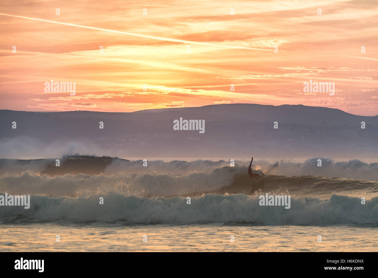 Gwithian, Cornwall, UK. 30th Cotober 2016. UK Weather. With temperatures at sunset of 17 degrees C, surfers and dog walkers make the most of the sea at sunset. Credit:  Simon Maycock/Alamy Live News Stock Photo