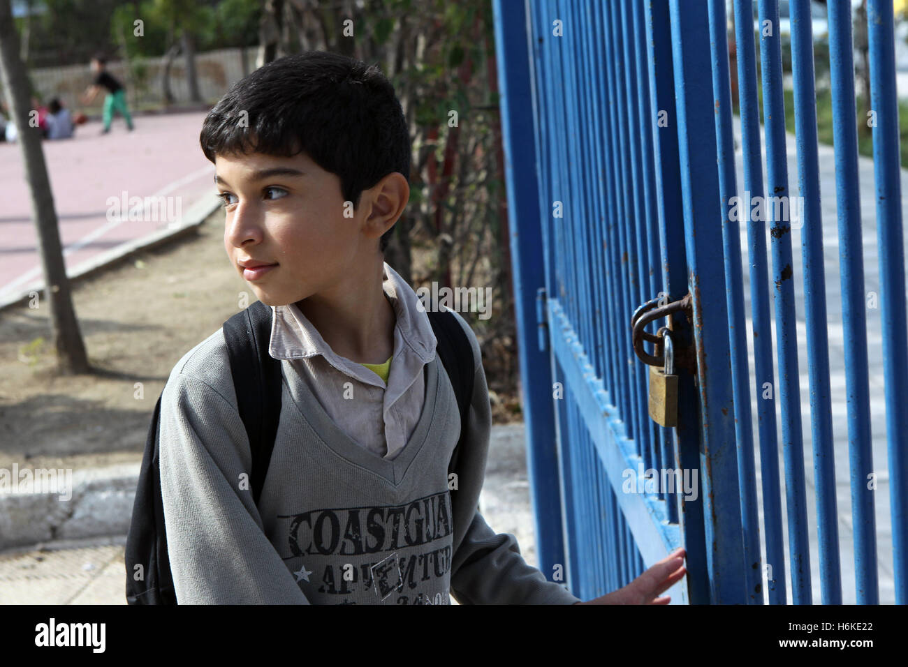 Athens, Athens. 19th Oct, 2016. A young boy from Syria waits in the courtyard of the 2nd Tavros Elementary School to enter his classroom, in Athens, Greece on Oct. 19, 2016. Under the new refugee schooling program which was introduced in early October by the Greek Ministry of Education, a total of 10,000 refugee children aged 6 to 15 years old in Greece are expected to attend four-hour lessons every day in 150 schools all over Greece within the next few weeks. © Marios Lolos/Xinhua/Alamy Live News Stock Photo