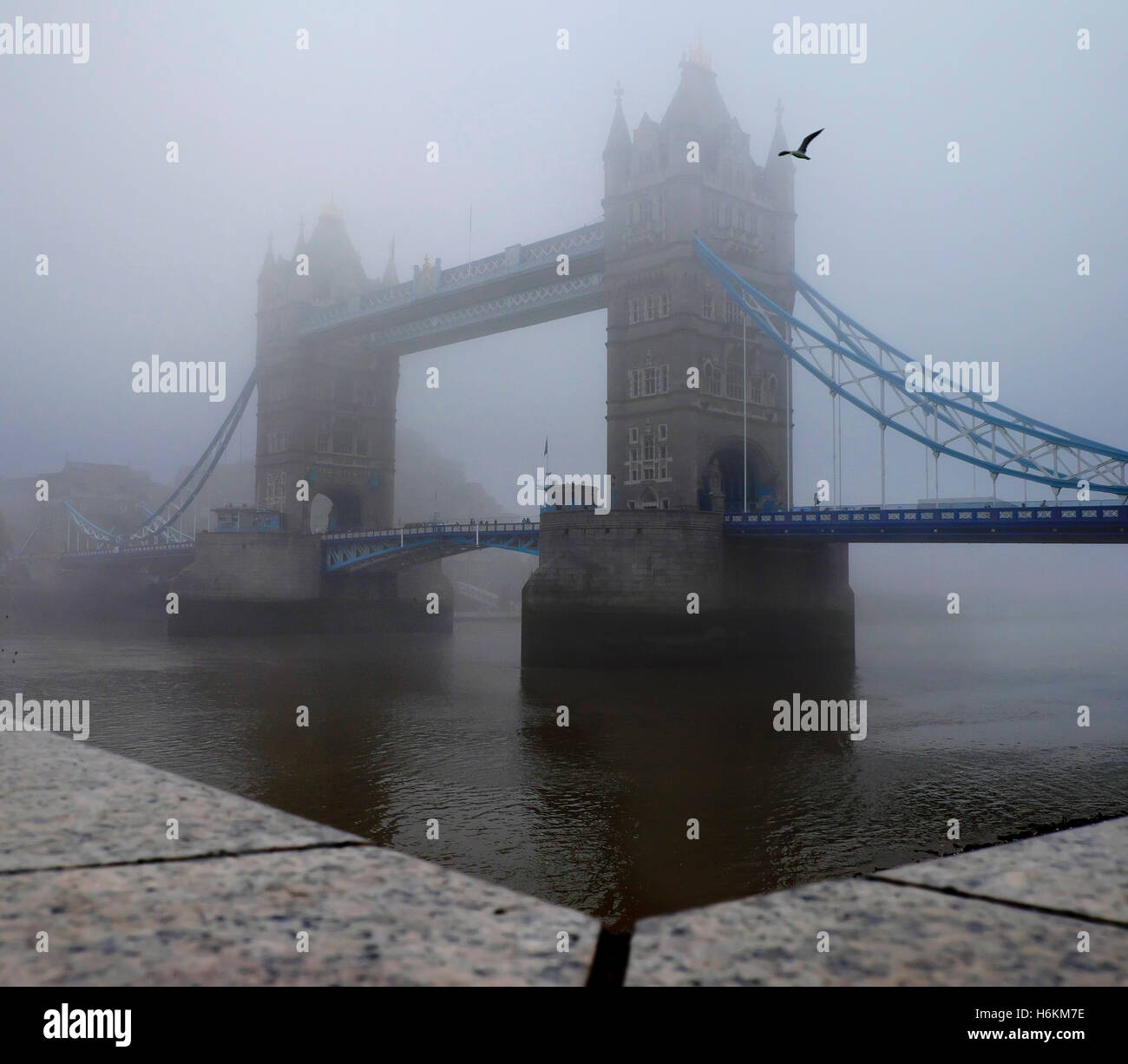 Tower Bridge is shrouded in thick fog on a gloomy day in London Stock Photo