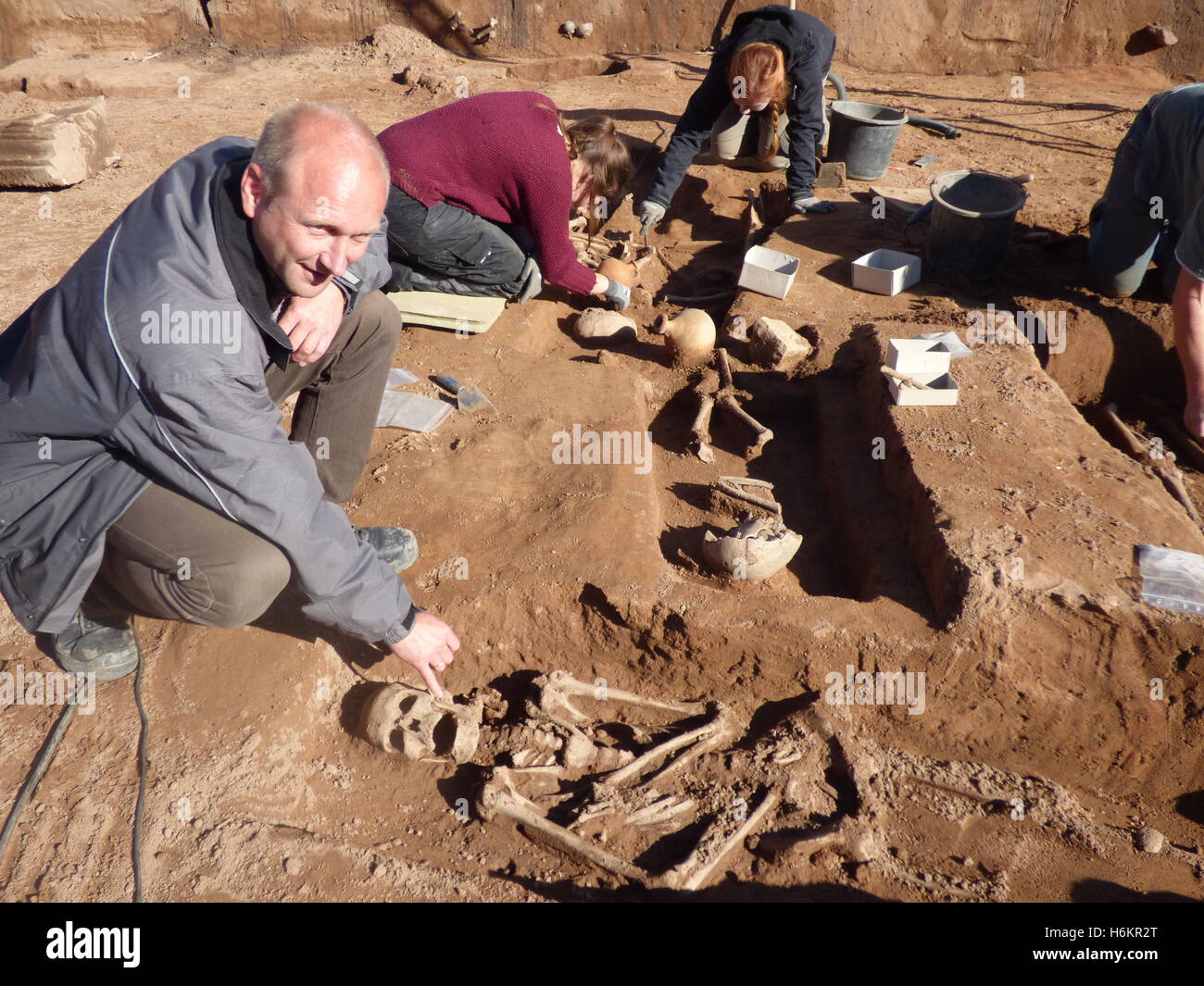 Trier, Germany. 31st Oct, 2016. Archaeologist Joachim Hupe (l) pointing at a skeleton in Trier, Germany, 31 October 2016. Archaeologists excavated 260 Roman graves from between 30 to 40 and 250 to 260 A.D. during a nine-month excavation period on a Roman cemetery in Trier. PHOTO: BIRGIT REICHERT/dpa/Alamy Live News Stock Photo