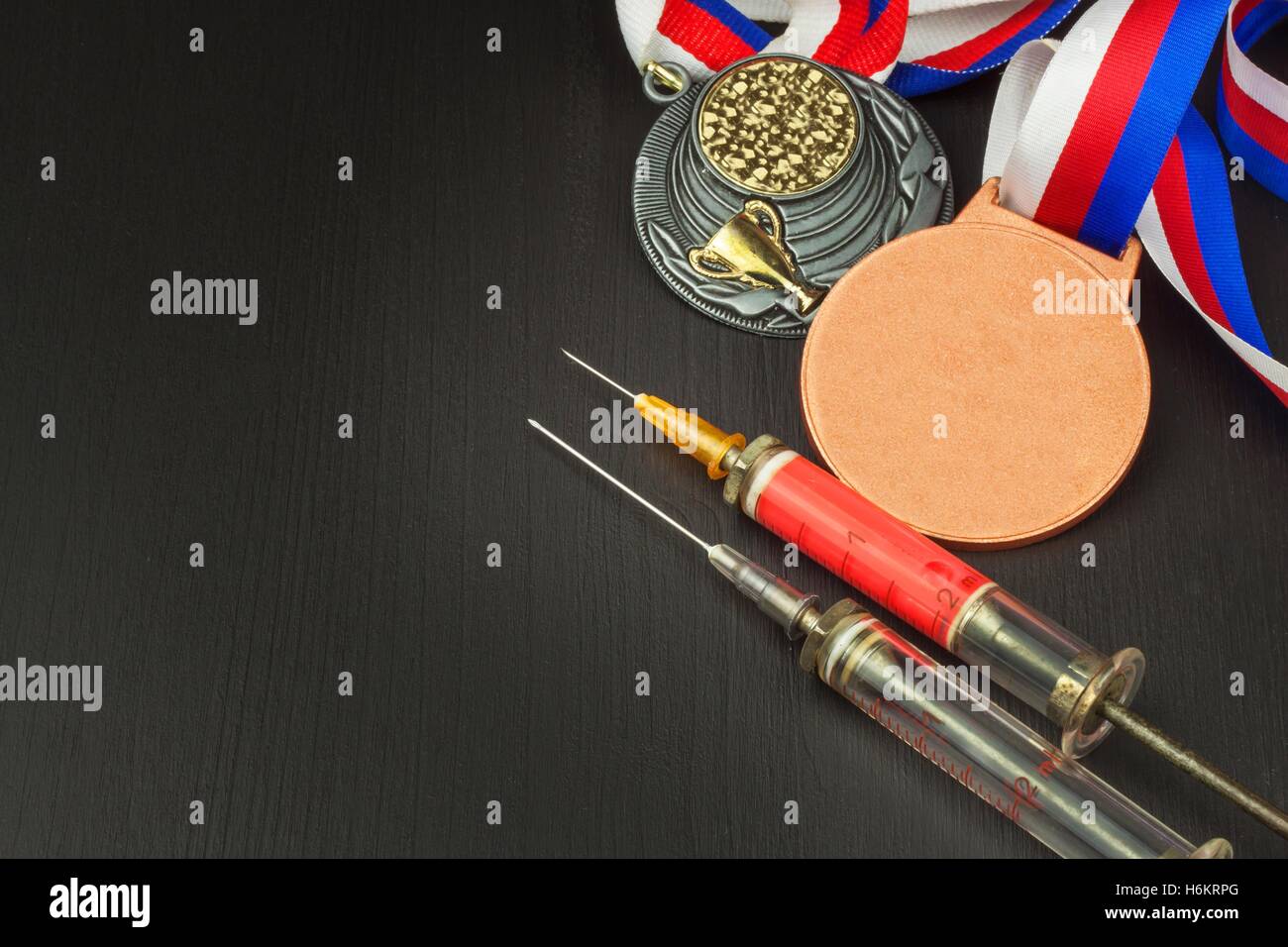Syringe and medals. Doping in sport. Abuse of anabolic steroids for