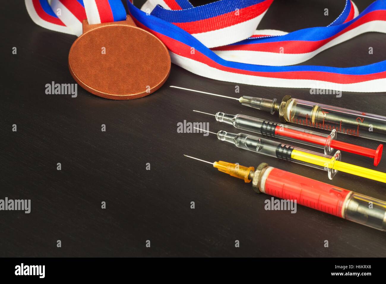 Syringe and medals. Doping in sport. Abuse of anabolic steroids for