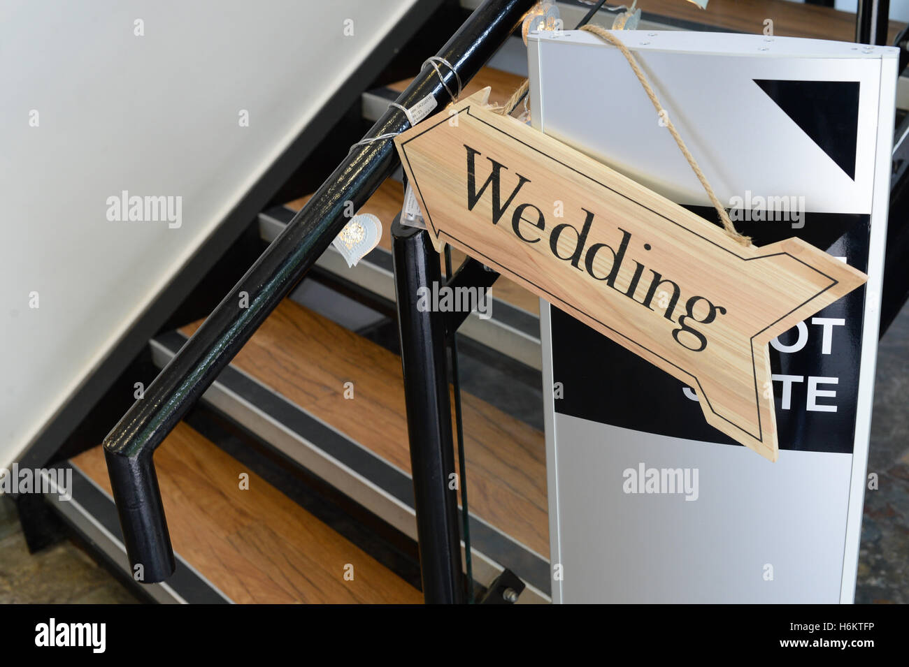 Wedding arrow sign pointing upstairs, wedding venue decor. Stock Photo