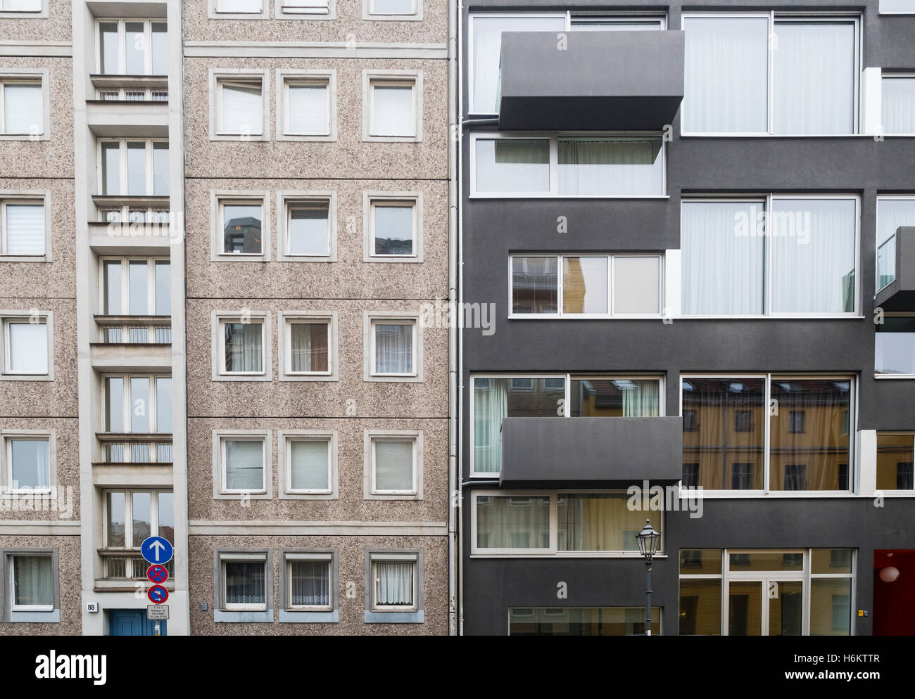 Contrast between old east German era apartment building and new luxury
