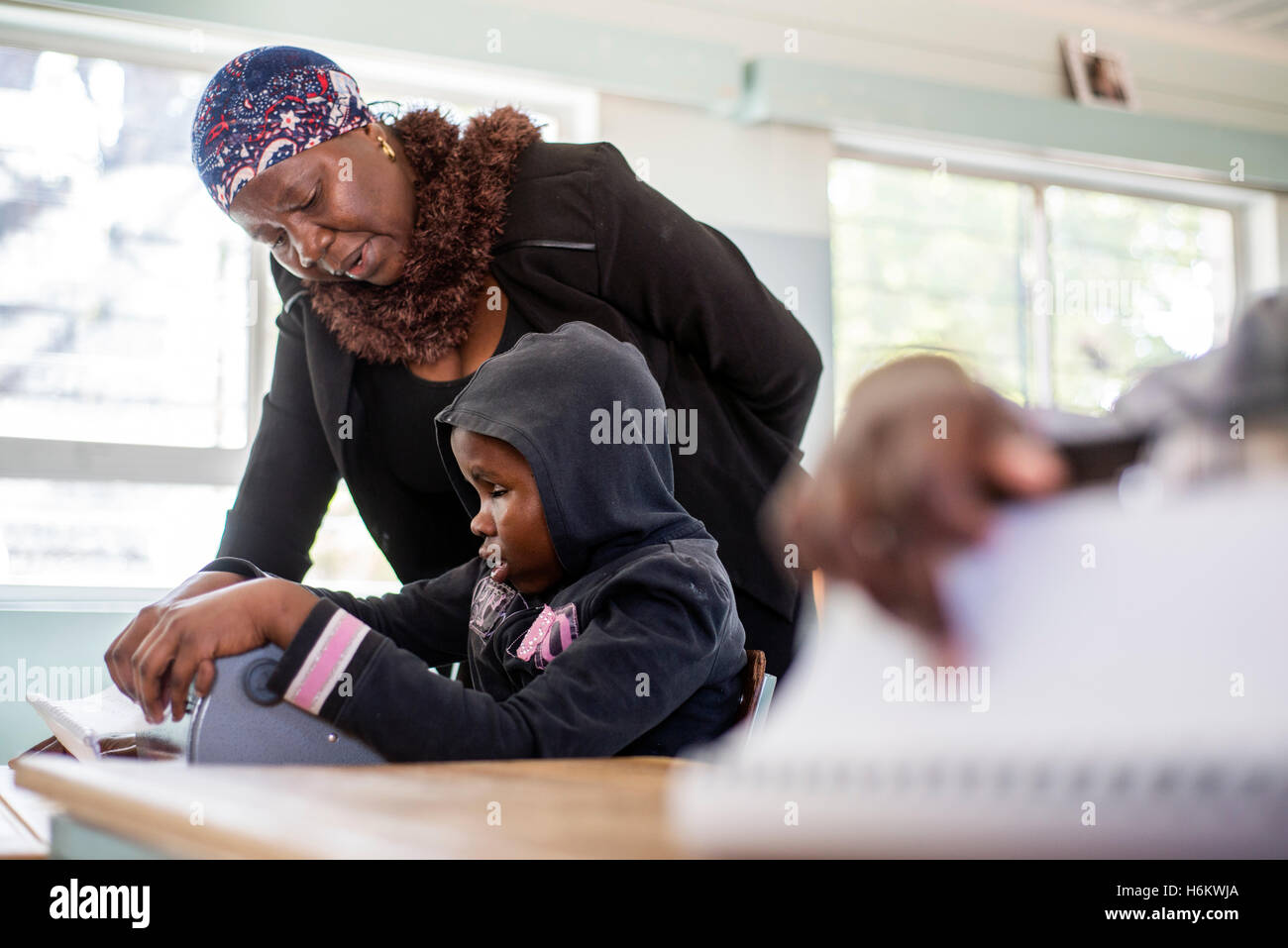 A teacher Esther Washinana helps the visually impaired learner to use