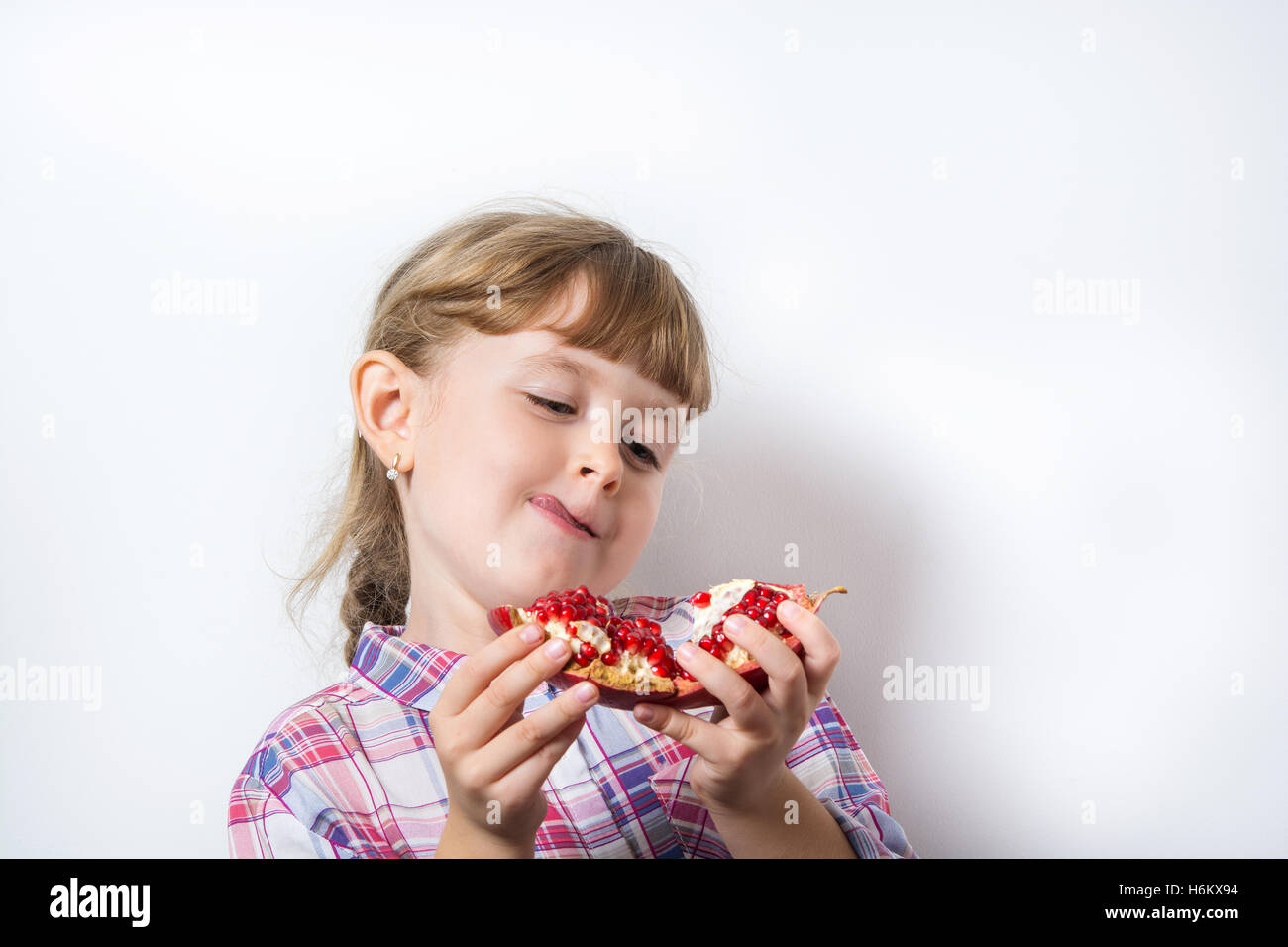 little girl eats juicy pomegranate Stock Photo