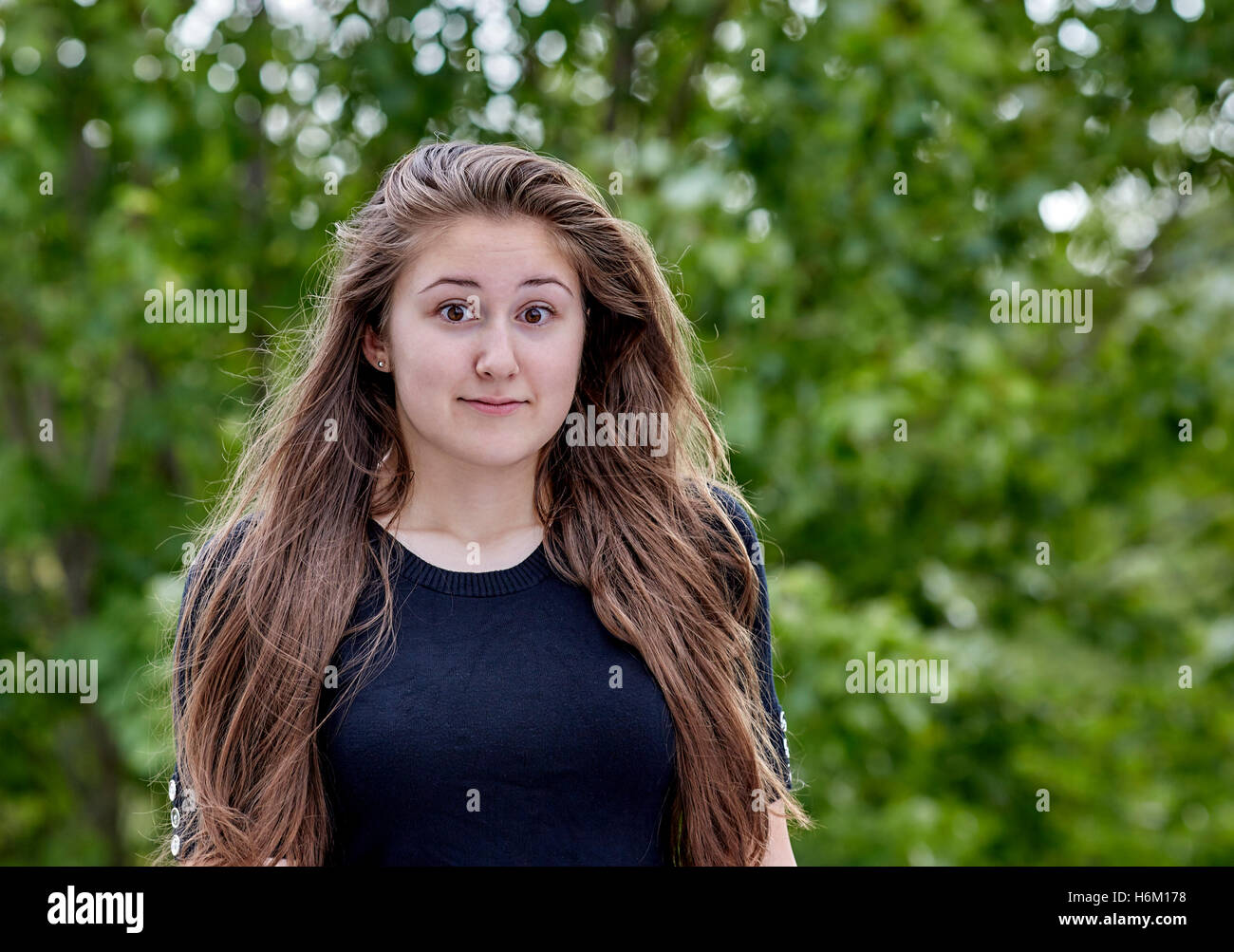 Fearful young woman with long hair expressiing apprehension and fear Stock Photo