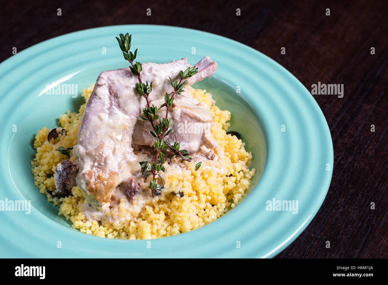 Stewed rabbit meat in creamy sauce with herbs and couscous Stock Photo ...