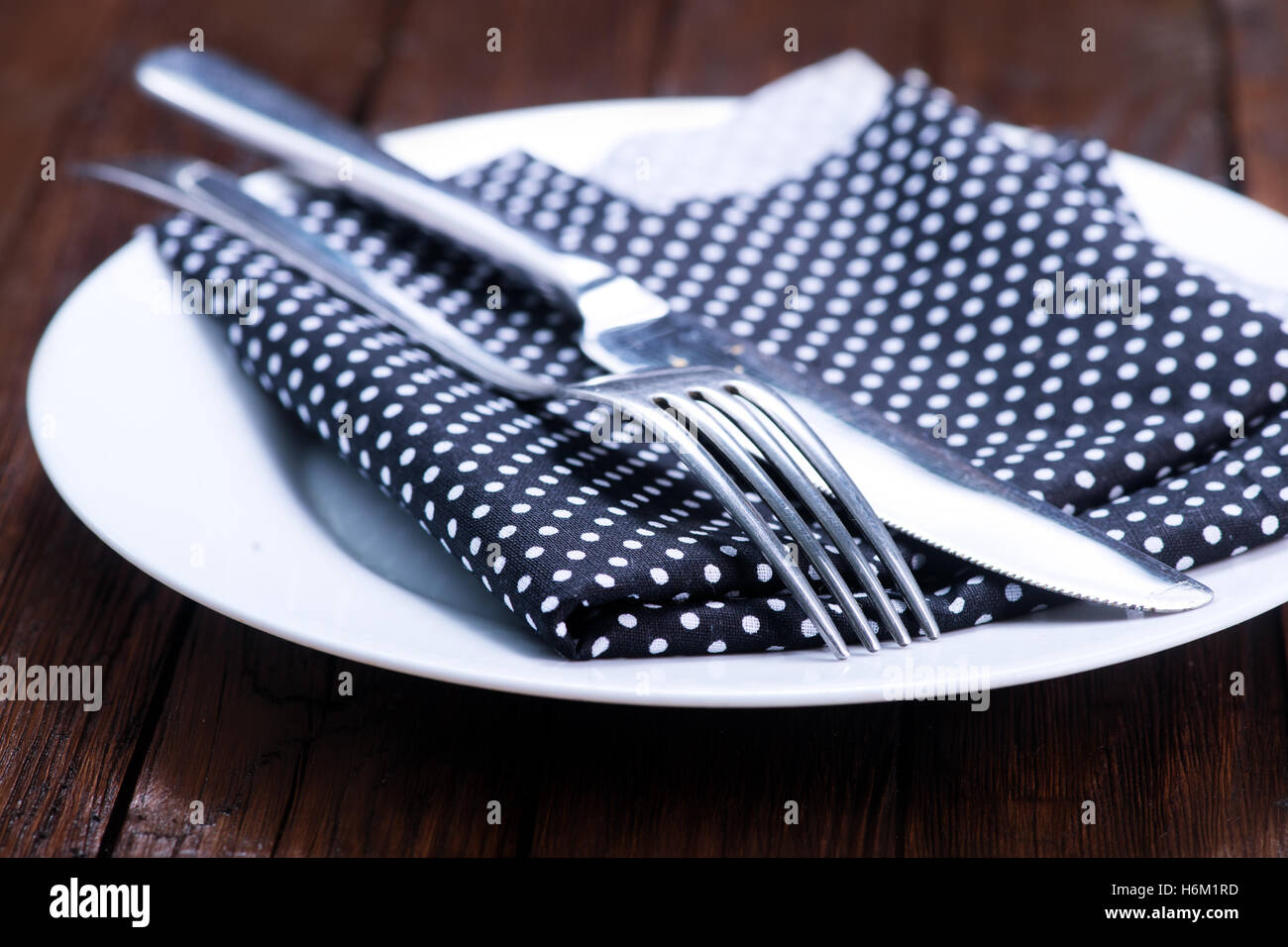 Dishes in kitchen. Knife, spoon and fork with serviette over dish Stock