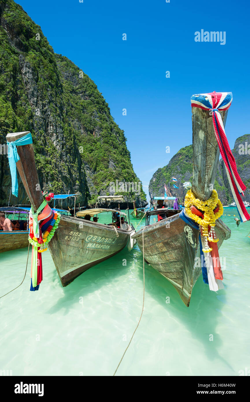 MAYA BAY, THAILAND - NOVEMBER 12, 2014: Traditional Thai longtail boats decorated with good luck bow sashes. Stock Photo