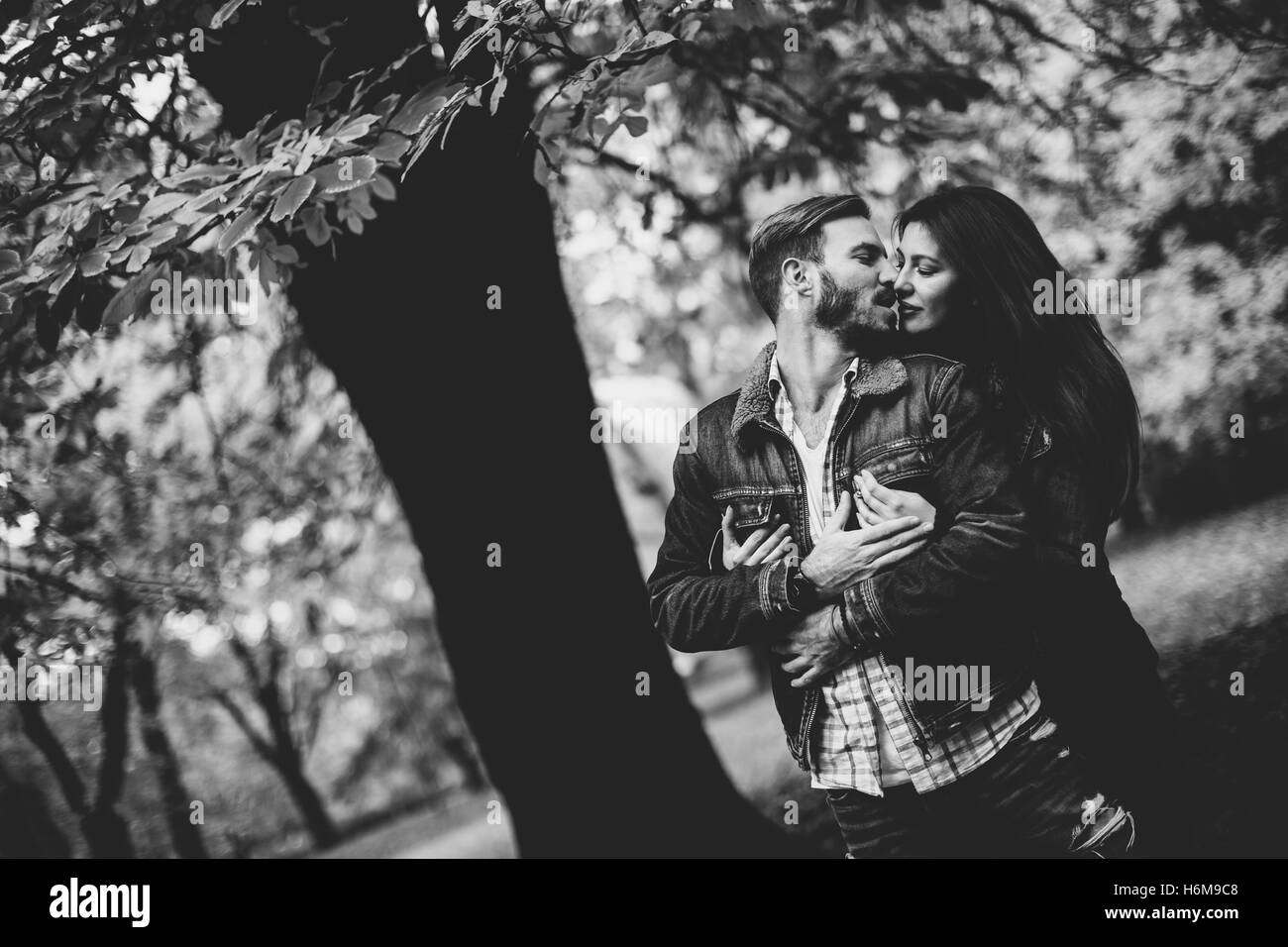 Loving couple exchanging tenderness in the autumn park Stock Photo