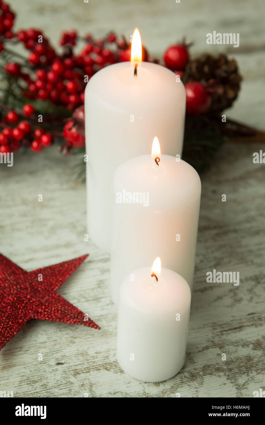 Burning candles in a Christmas setting with seasonal decorations Stock